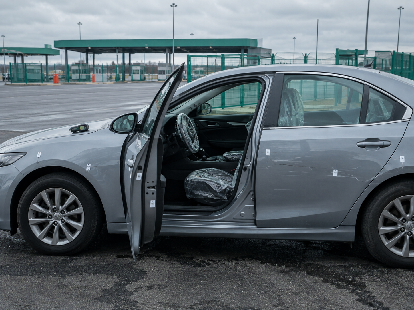 Osobni automobil na carinskom parkiralištu za vrijeme pregleda: navlake na sjedalima i numerirane oznake uz oštećenja na vratima